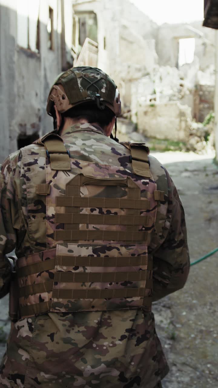 Young Soldier Walks Doing Reconnaissance In The Village Destroyed Streets