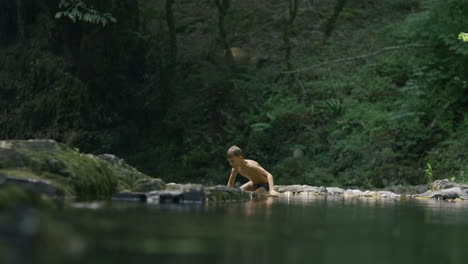 boy playing in a mountain stream