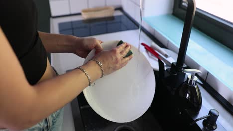 mujer lavando platos en la cocina