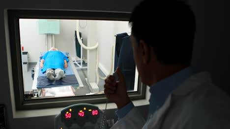 médico usando el panel de control de la unidad de rayos x en el paciente