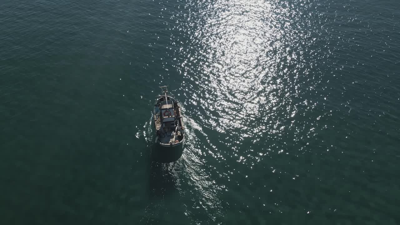 vista aérea del barco de pesca en aguas poco profundas, acercándose al horizonte