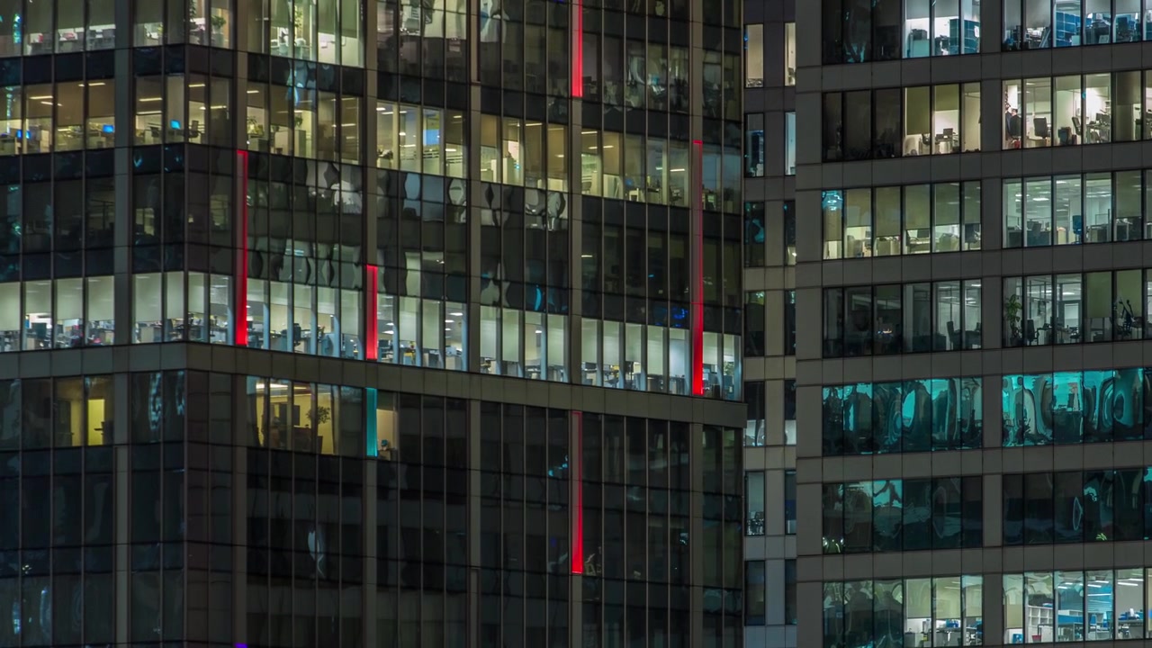 Vista de perto das janelas panorâmicas de escritórios nos arranha-céus do International Business Center da Cidade à noite, timelapse do alto.