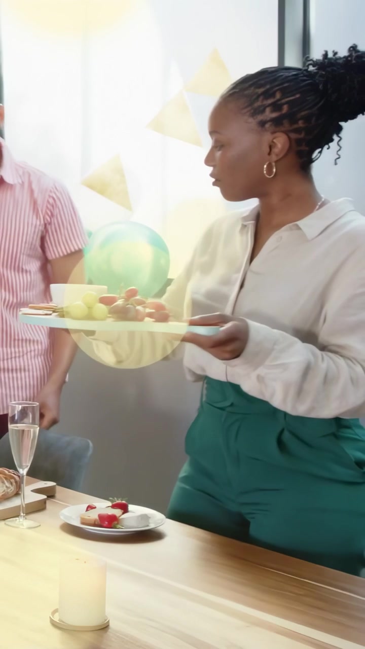 Donna che si avvicina alla vicina, in piedi e che raccoglie i piatti, sparecchiando la tavola a un evento con palloncini