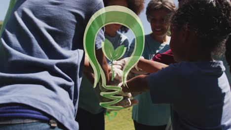 animación del logotipo de la bombilla verde sobre un grupo feliz de afroamericanos apilando las manos en el campo