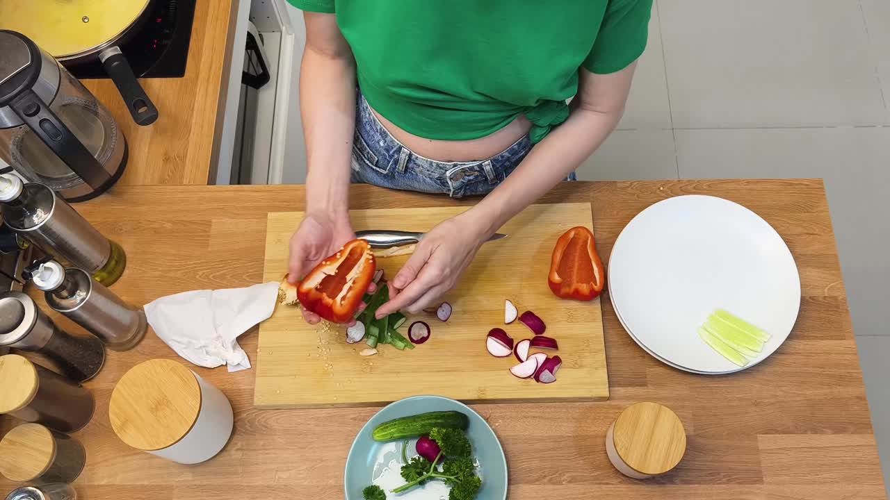 Woman preparing vegetables on a cutting board in the kitchen