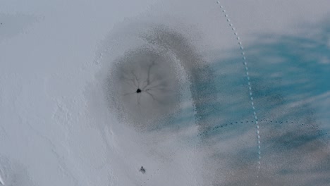 round hole in a frozen lake. a natural hole from an underwater spring