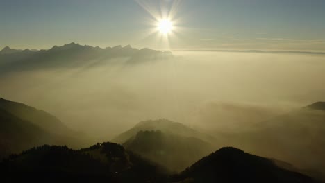 flying high above mist layer at sunset in alpine environment