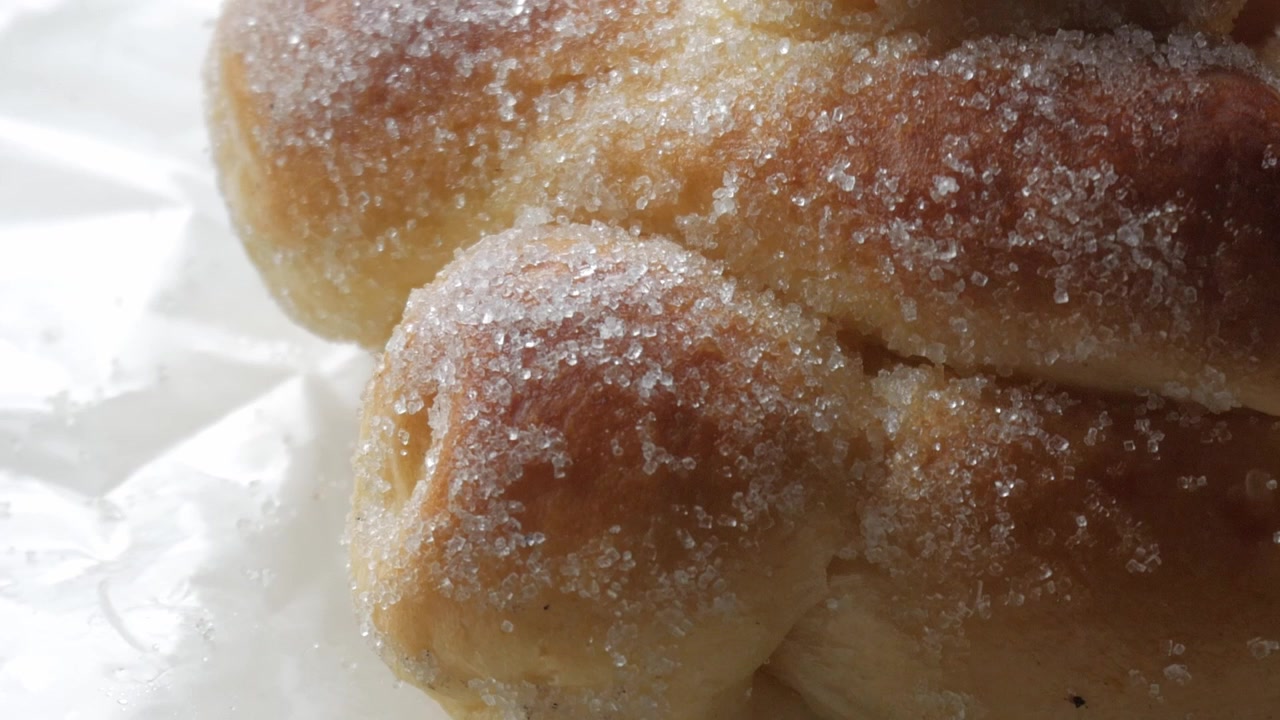 Sweet bread called Bread of the Dead (Pan de Muerto) enjoyed during Day of the Dead festivities in Mexico - closeup slow pan up