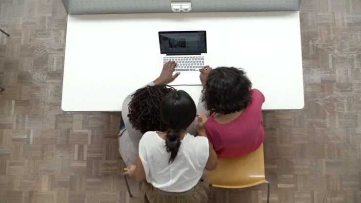 Vue de dessus de trois femmes regardant un ordinateur portable