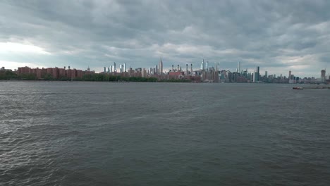 man looks out to the nyc skyline from one of the city's best vantage points in long island city queens as the drone flys by to admire the cityscape