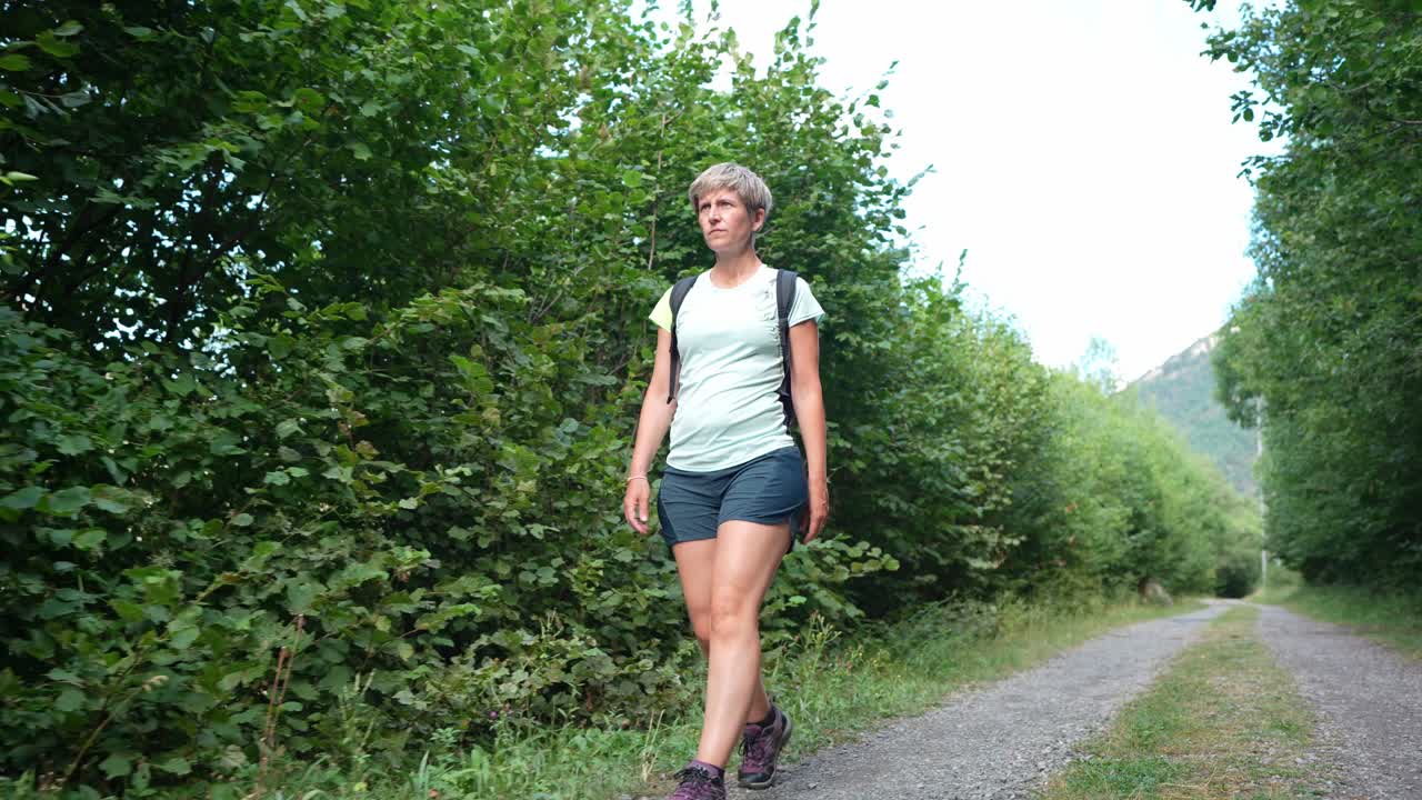 Eine Frau wandert auf einem Waldweg