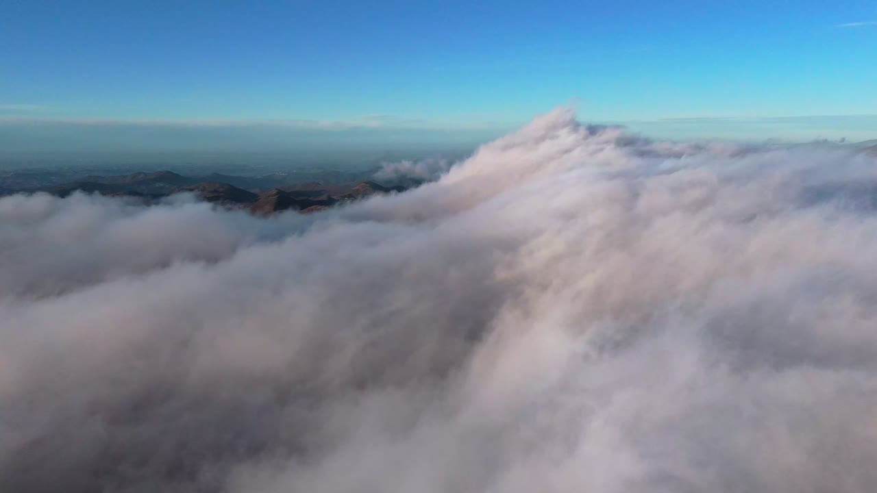 Vista aerea di nuvole sopra le montagne all'alba, pacifica e serena