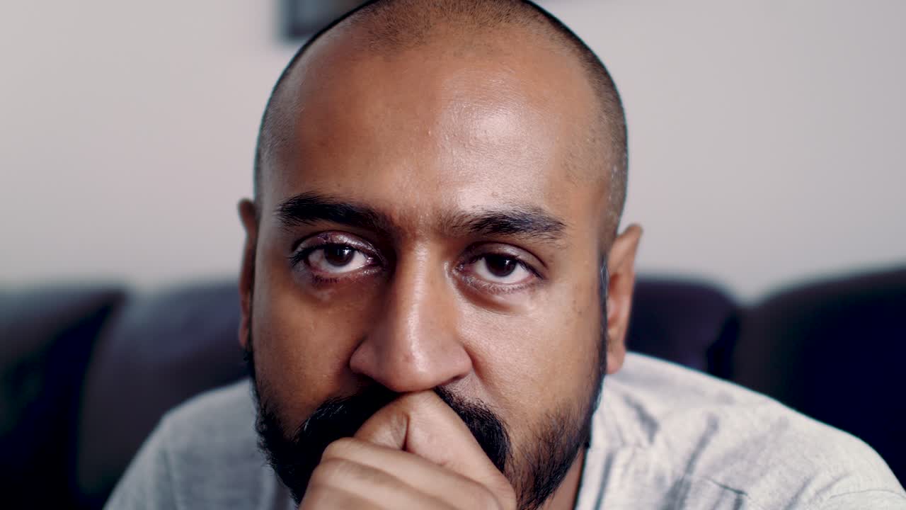 hombre asiático asintiendo con desaprobación a la cámara