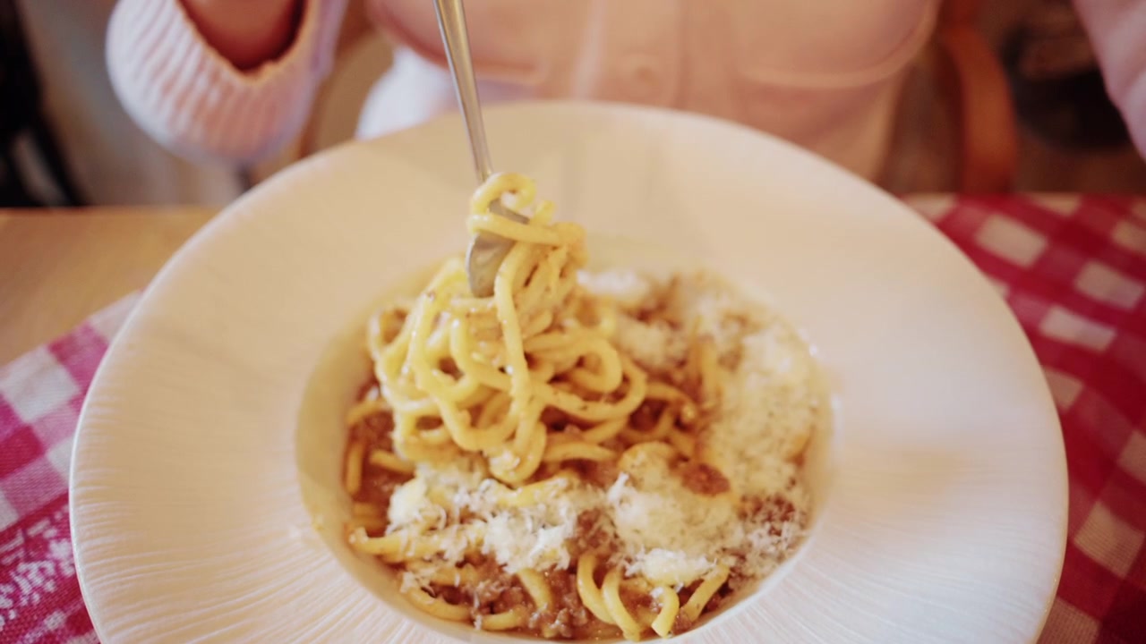 Primo piano di un piatto di pasta cremosa servito su un piatto, con una texture ricca e tonalità calde