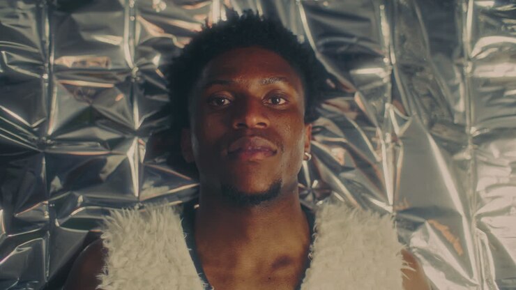 Ritratto di uomo afroamericano sdraiato su un foglio metallico