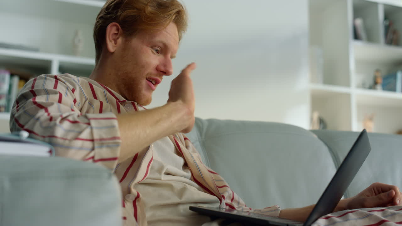 선생님은 가정 사무실에서 온라인 수업을 시작합니다. 웃는 남자가 손을 흔들고 전화합니다.