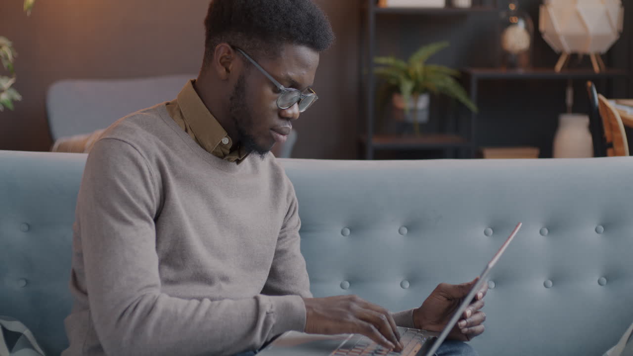 Young Man Working on Laptop on a Couch
