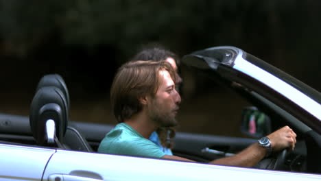 man closing up his car door while his girlfriend look at him