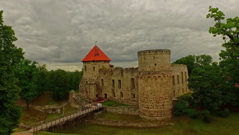 drone revealing view of cesis castle on a cloudy day in latvia