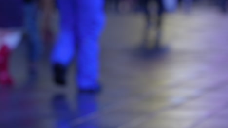 네온 불빛과 함께 밤에 젖은 뉴욕시 거리에서 초점이 맞지 않는 사람들과 교통의 슬로우 모션