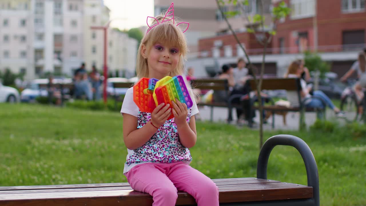 niña niño mostrando muchas coloridas burbujas de silicona suave juguete sensorial, niño jugando pop it juego