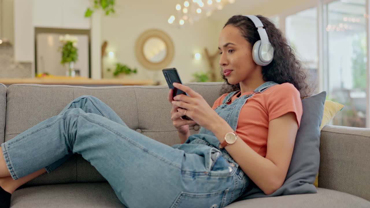 Woman, phone and headphones on sofa dancing