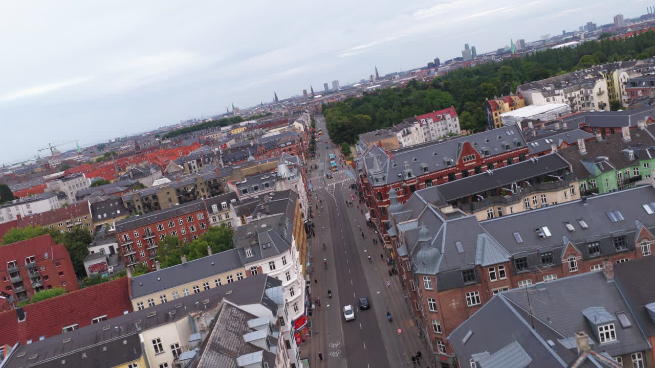 Aerial drone view of Norrebrogade, one of the busiest streets in Norrebro, Copenhagen, Denmark, looking towards the city center skyline