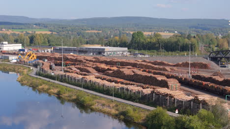 norsenga tømmerterminal timber yard with stacks of logs on gomma river, aerial