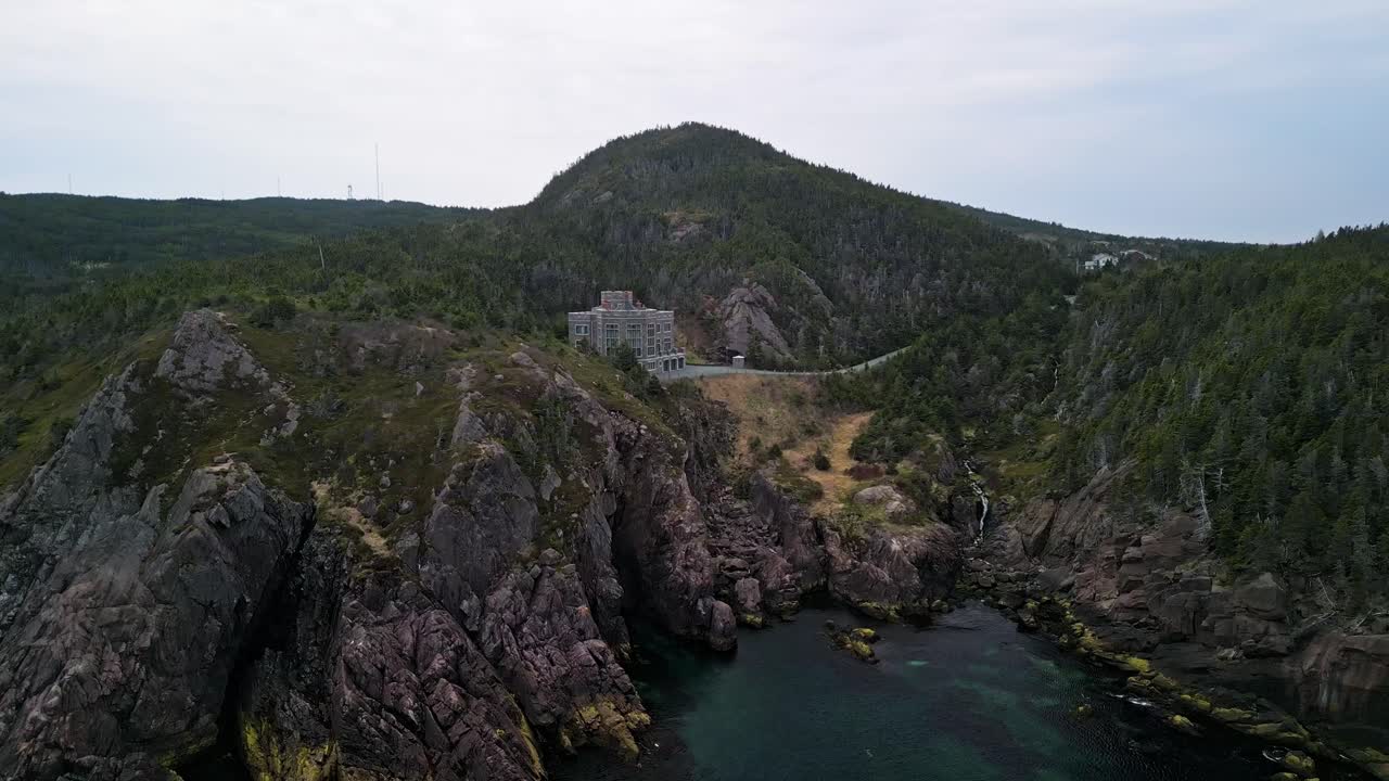 A drone shot showing a small castle nestled in the rocky hills of Logy Bay In Newfoundland Canada.