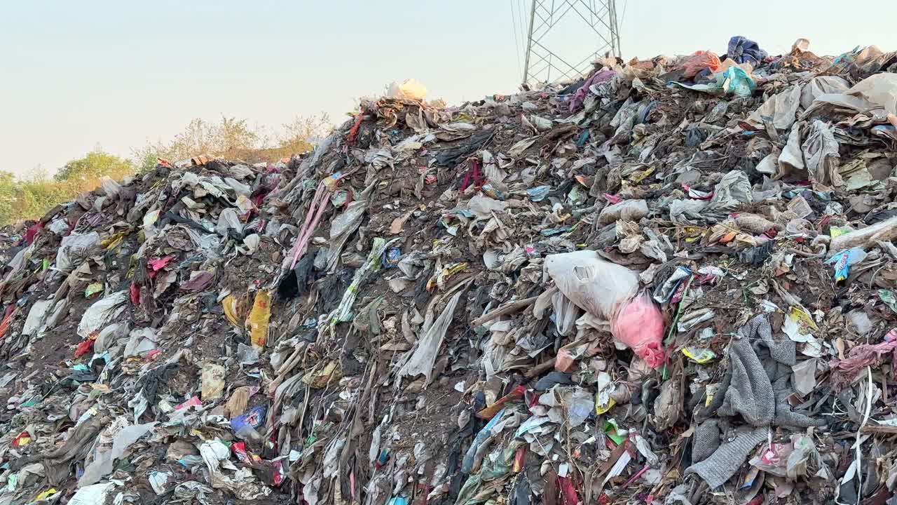 tracking shot of a pile of garbage at the dump yard, microplastic pollution