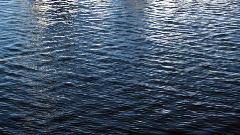 Patterns-of-blue-ocean-waters-moving-with-reflection-of-a-boat-seen-in-Santa-Monica