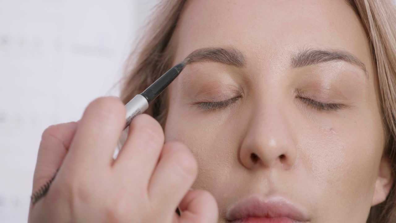 Woman applying makeup to eyebrows