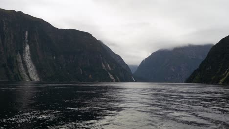 panning view of tree avalanche affected hillside areas in milford sound on a cloudy day