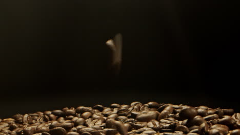 Kaffeebohnen-Fallen-Von-Oben-Auf-Eine-Holzoberfläche
