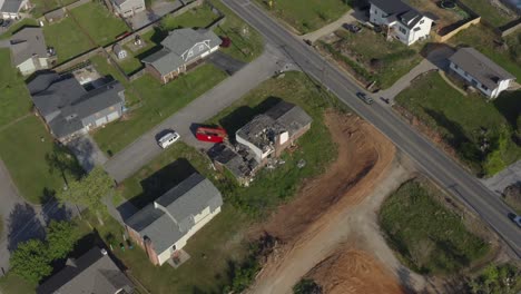 Toma-Aérea-De-La-órbita-De-Un-Dron-De-Una-Casa-Dañada-Por-Una-Tormenta-Con-Autos-Que-Pasan-Casualmente,-América-Suburbana