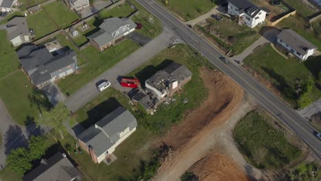 toma aérea de la órbita de un dron de una casa dañada por una tormenta con autos que pasan casualmente, américa suburbana