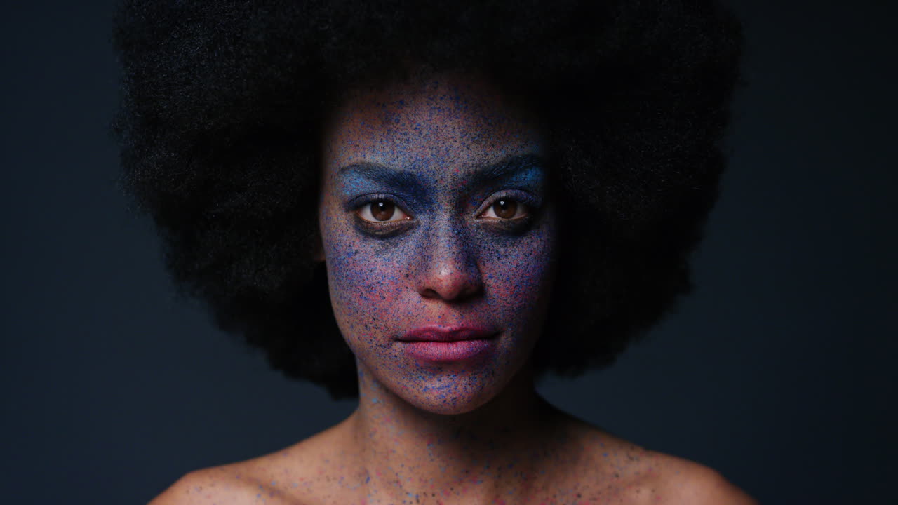 retrato de una hermosa mujer afroamericana con rostro exótico, pintura corporal, arte corporal, mujer misteriosa con maquillaje colorido, luz parpadeando en un fondo oscuro, concepto de expresión creativa
