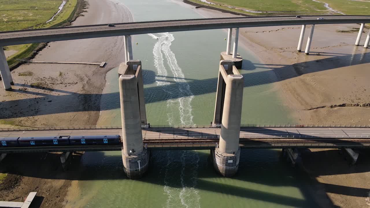 킹스페리 다리를 따라 이동하는 기차와 영국의 셰피 교차로를 운전하는 차량의 파노라마