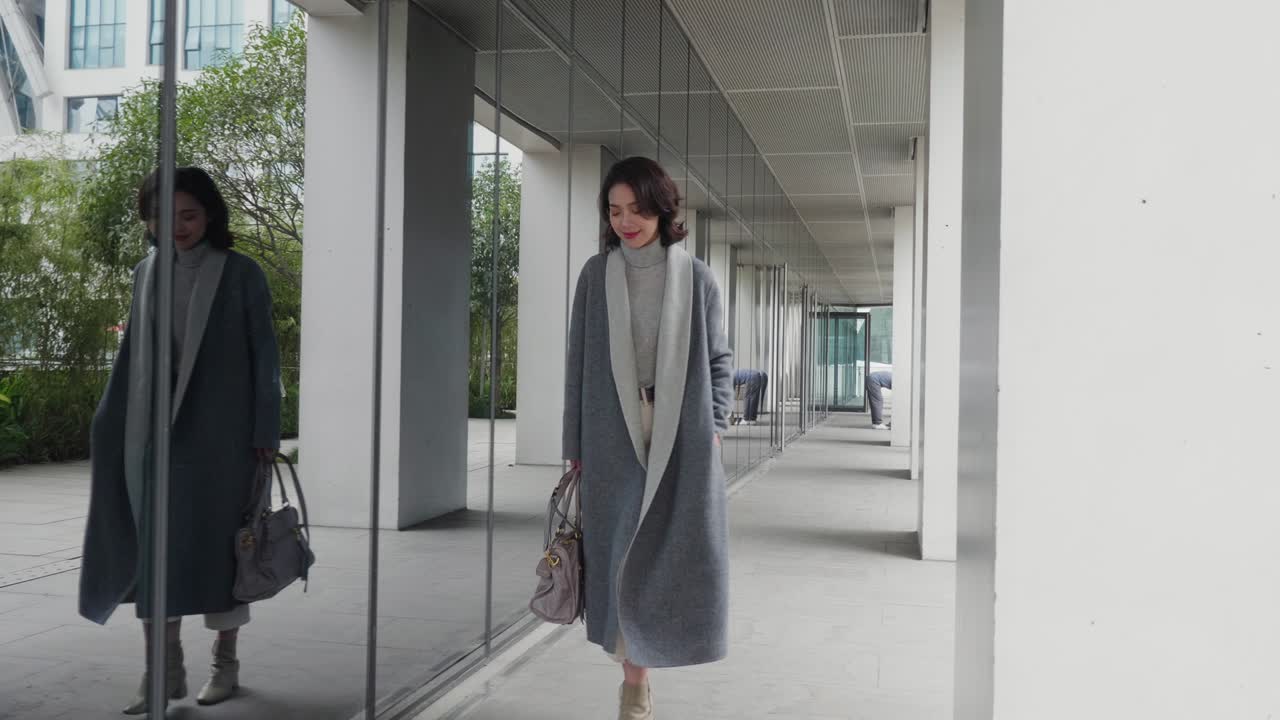 pretty asian woman in fashionable coat,is Walking