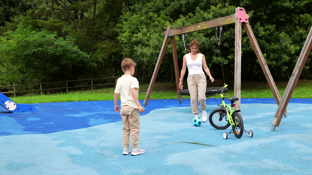 A child plays with his mother in a playground