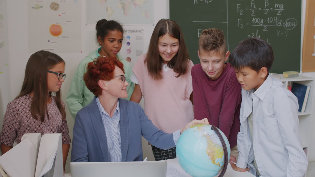 Teacher and Children Looking at Globe in Classroom