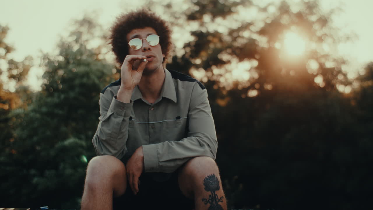 Man Smoking Outdoors at Sunset