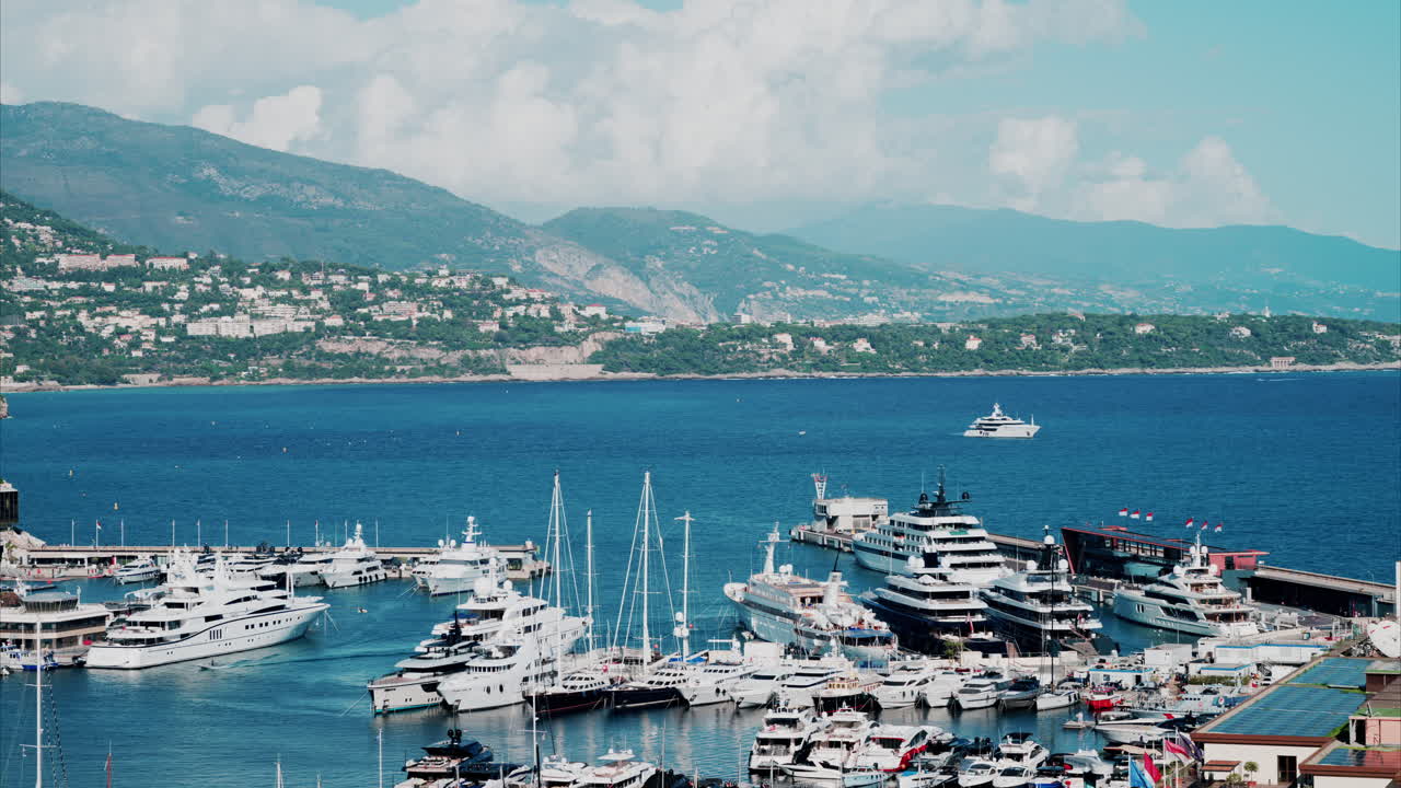 Aerial view of boats docked in the Monaco Marina with the skyline of the city on the background