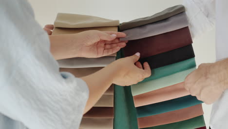 the buyer chooses the fabric in the store, the seller holds a palette with images