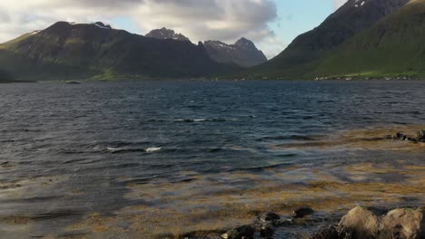 mujer con una bandera de noruega ondeando en el fondo de la naturaleza