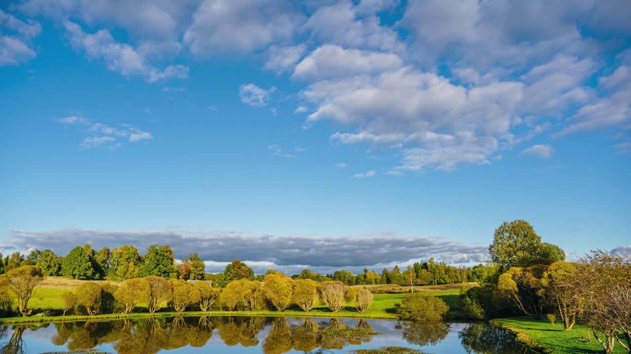 Day to night timelapse in verdant countryside. From cloudy weather till clear sky sunset with fog settling on the ground in the evening.