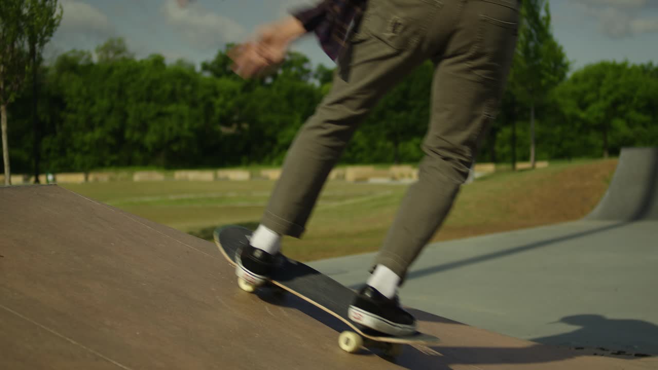 Male skateboarder doing a backside kick flip at a skatepark