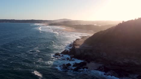 drone aerial shot of later afternoon spoon bay wamberal beach afternoon sunset along pacific ocean beach central coast nsw australia 4k