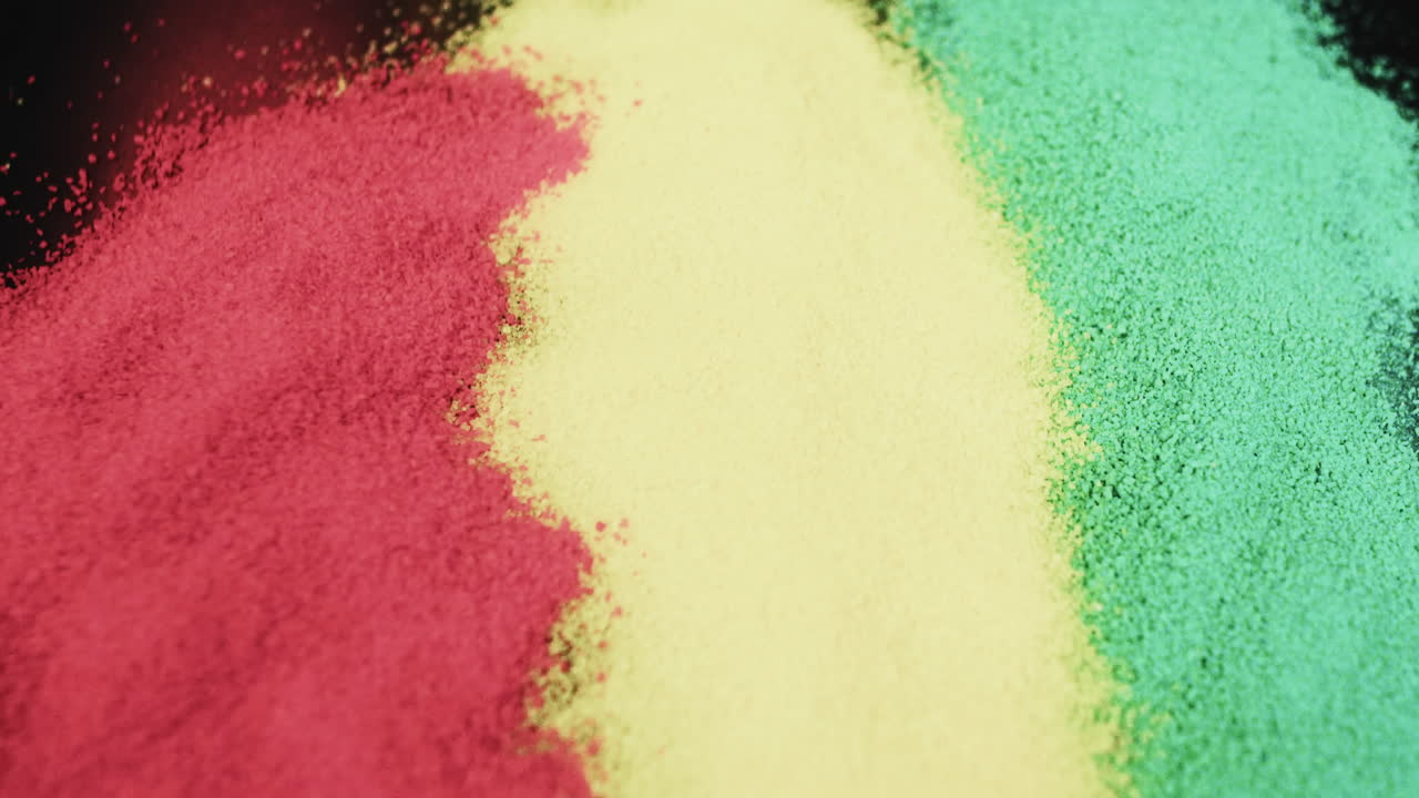 Ideo of red, yellow and green powders with copy space on black background