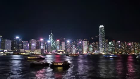 enjoy breathtaking views of hong kong's skyline illuminated at night. the vibrant lights reflect beautifully on the water as boats navigate the harbor, showcasing the city's lively atmosphere.